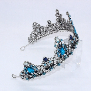 Détail d'une couronne argentée vintage avec pierres bleues et claires sur support