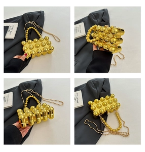 Detail of gold beaded sphere handbag with metallic chain strap and textured surface