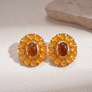 Vintage style amber agate oval stud earrings with gold metal frame on stone base