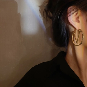 Chic gold V-logo hoop earrings for women featuring a minimalist metal circle design