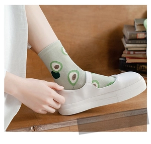 Close-up of green cotton crew socks with avocado cartoon print and Mary Jane shoes