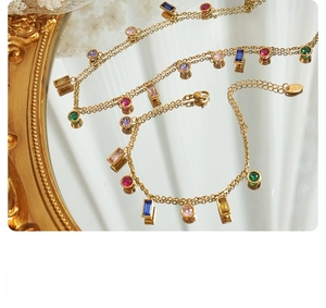 Detail of gold double-chain bracelet with multi-color zircon stones and 925 metal tag