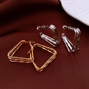 Detailed view of gold and silver geometric triangle earrings with wavy metal textures