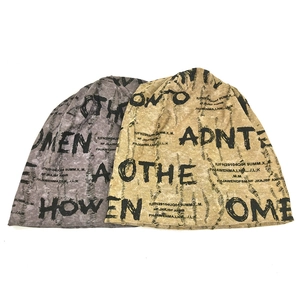 Detailed flat lay of distressed grey and beige beanies with street style letter prints