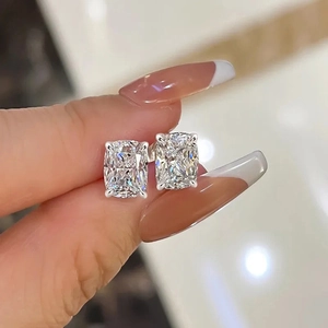 Macro detail of cushion-cut zircon stud earrings in a classic four-prong silver setting