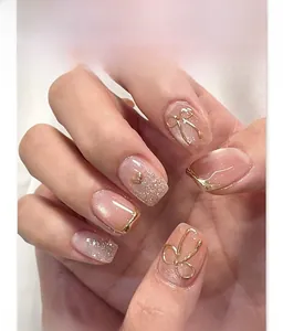 Detail of short square cat-eye press-on nails with 3D gold bows and glitter accents