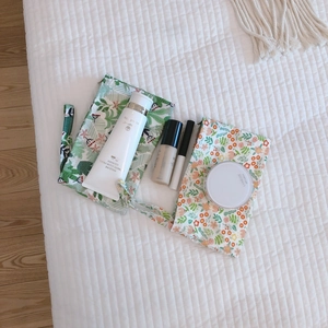 Mini cotton pouches with floral and tropical leaf patterns on a white quilted background