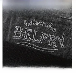 Detailed macro view of silver silk embroidery on a premium washed gray cotton bucket hat