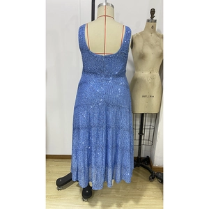Détail d'une robe de soirée à paillettes bleues avec un dos en U profond et fermeture éclair cachée