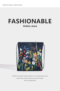 Close-up of vibrant 3D flower and butterfly embroidery on a navy denim shoulder bag