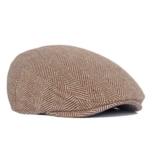 Detail of classic brown herringbone tweed fabric texture on a vintage newsboy cap