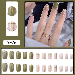Green and pink press-on nails with plaid patterns, gold glitter and French tip finish