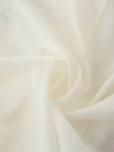 Gros plan détaillé sur la texture du tissu en lin crème avec des plis naturels