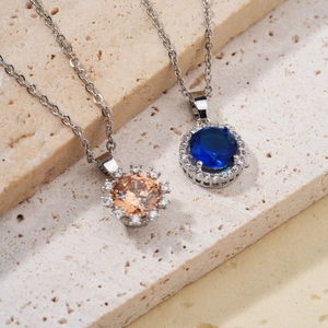 Elegant halo pendant necklaces with round cut blue and champagne crystals on beige stone