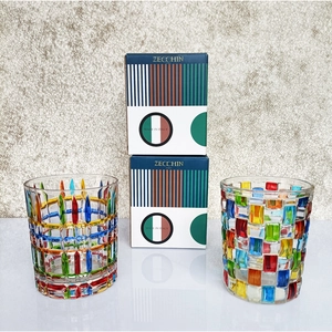Detail view of two hand-painted woven crystal whiskey glasses with Zecchin gift boxes