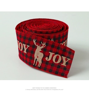Detail of red and black buffalo plaid ribbon with golden reindeer and JOY prints