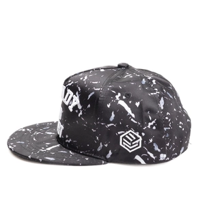 Close-up of snapback hat featuring marble print fabric and 3D letter embroidery detail