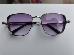 Detail of steampunk square sunglasses with purple gradient lenses and silver metal frame