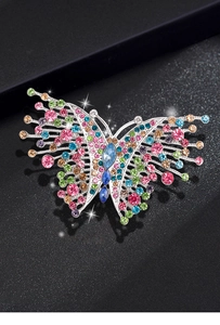 Detailed macro shot of vintage butterfly brooch with colorful rhinestones on black background