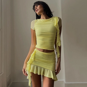 Detail of yellow mesh two-piece set featuring ruched short sleeves and ruffled mini skirt