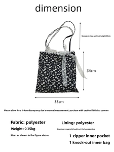 Detailed view of black floral tote bag featuring white lace trim and bow knot detailing