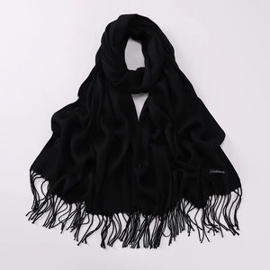 Detailed close-up of a black cashmere scarf featuring soft texture and elegant tassels