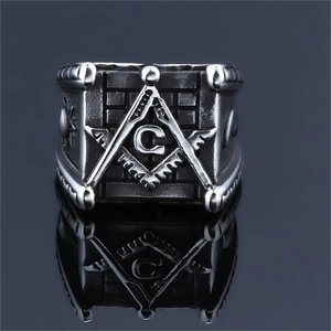 Macro shot of stainless steel Freemason ring with G symbol on a gradient background