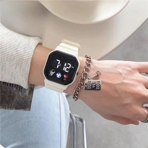 Close-up of white silicone digital watch featuring astronaut dial and silver chain bracelet