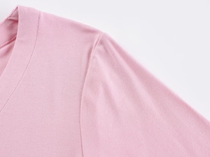 Close-up of pink knit T-shirt showing fine texture and V-neckline stitching detail