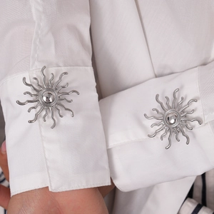 Close-up of silver sunburst cufflinks on a white shirt cuff for a stylish formal look