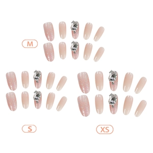 French oval press-on nails with pink gradient glitter and large rhinestone gems in three sizes