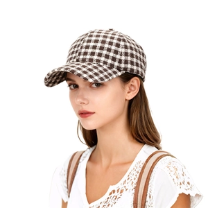 Detailed close-up of brown and beige plaid baseball cap texture on a female model