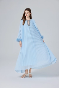 Détail de la robe longue plissée bleu clair avec col en cristal et poignets en plumes
