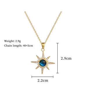 Detailed view of gold sunburst pendant with blue gem and clear crystals on 45cm chain