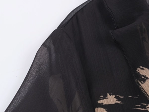 Detail of sheer chiffon sleeve with beige brushstroke print and flared elastic cuff