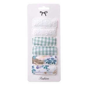 Detail of 6-piece embroidered floral and plaid fabric square hair clips on card