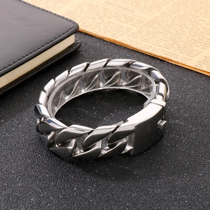 Detailed view of silver titanium steel Cuban link bracelet on a textured dark surface