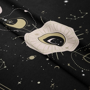 Macro shot of gold celestial patterns and mystic eye on black tarot wall tapestry