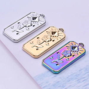 Three rose and eye embossed pendants in silver, gold, and iridescent stainless steel finishes