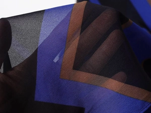 Dettaglio del tessuto in chiffon con stampa geometrica che mostra trama e trasparenza