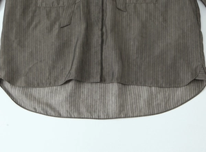 Detail of taupe striped blouse featuring curved hem and smooth vertical fabric texture