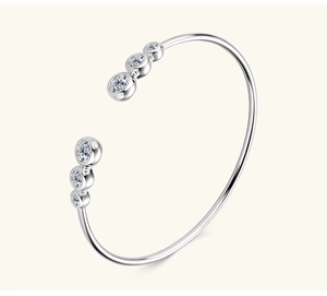 Vista dettagliata del bracciale rigido in argento con sei pietre di moissanite a taglio tondo