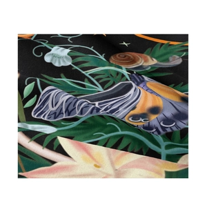 Close-up of tapestry fabric showing detailed butterfly and snail floral print texture