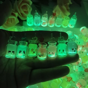 Luminous mini bottles with emoji faces glowing brightly in a dark setting