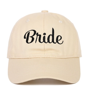 Close-up of beige cotton baseball cap featuring black embroidered Bride cursive text