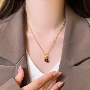 Detail of 18k gold plated necklace featuring a red gourd pendant on a female model