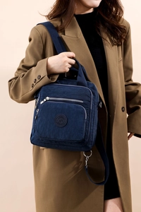 Détail du sac bandoulière en nylon bleu marine avec compartiments zippés et logo