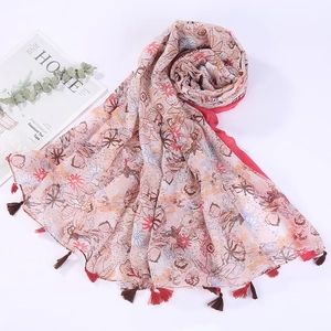 Detail shot of lightweight floral cotton linen scarf with colorful tassel edge trim