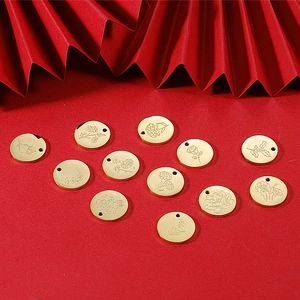 Golden stainless steel birthday flower charms arranged on a festive red background