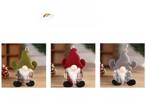 Detailed view of three hanging Christmas gnome dolls in green, red, and grey plaid fabrics